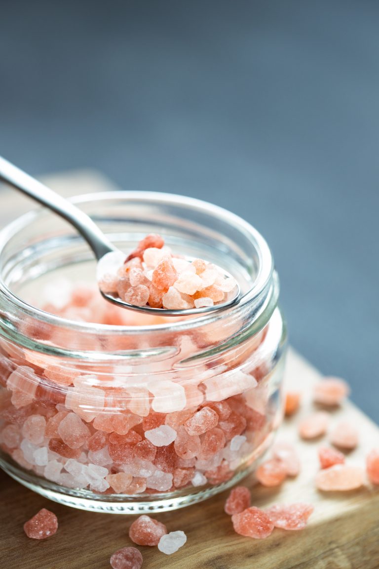 Pink Himalayan salt in tea spoon and glass jar.